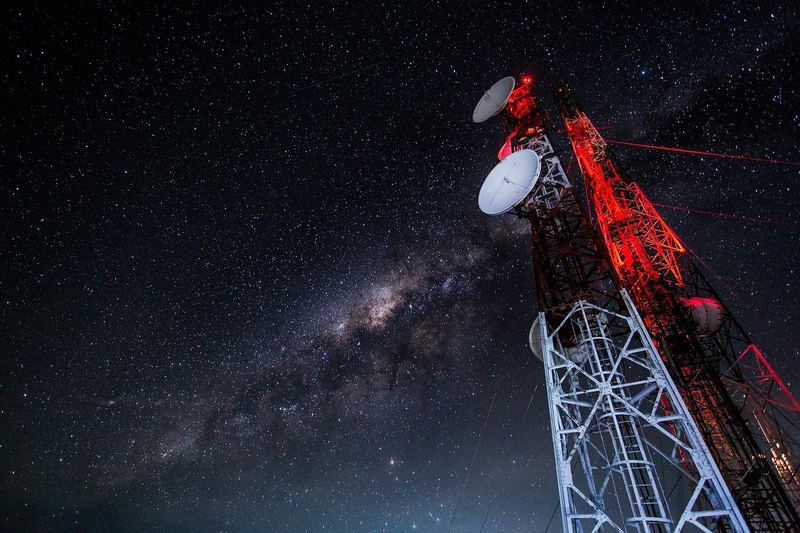 Antennmast med röda och vita fält mot stjärnhimmel